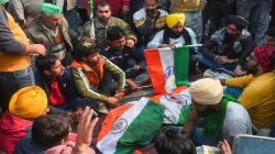 Farmers sit near the mortal remains of a protestor, who died after his tractor overturned during 'Ki- India TV Hindi