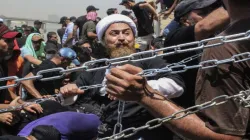 Iraqi protesters use chains to try to remove concrete barriers on their way to the Parliament buildi- India TV Hindi