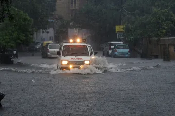 <p>An ambulance makes way through a flooded road after...- India TV Hindi