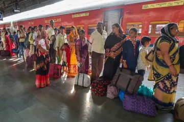 <p>Migrant workers wait to board a train out of Gujarat in...- India TV Hindi