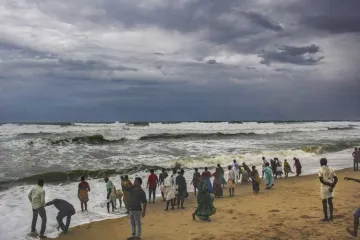 <p>Villagers at the beach as dark clouds hover above the...- India TV Hindi