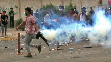 <p>Iraqi security forces fire tear gas while...- India TV Hindi