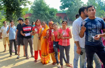 <p> Voters stand in a queue to cast their votes at a...- India TV Hindi