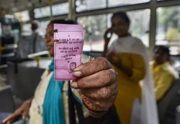 <p>A woman shows the 'pink ticket' during her ride on a DTC...- India TV Hindi