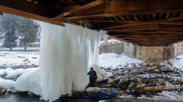 <p>A man looks at icicles hanging from a bridge after...- India TV Hindi