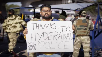 <p>A local youth holds a placard commending the Hyderabad...- India TV Hindi