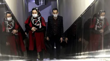 People wear masks to help guard against the Coronavirus as they ride an escalator at a the metro sta- India TV Hindi