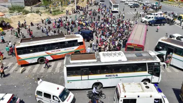 <p>Migrants board buses to their native village, during a...- India TV Hindi