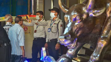 Security personnel use thermal screening devices on visitors to mitigate the coronavirus pandemic, a- India TV Hindi