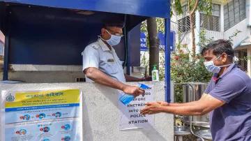 <p>Kolkata: A police person provides hand sanitizer to a...- India TV Hindi