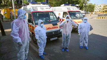<p>Medics wearing protective suits prepare to escort...- India TV Hindi