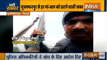 हाथ में बंदूक लेकर बच्चों को पढ़ाते हुए शख्स का वीडियो वायरल, पुलिस मामले की जांच में जुटी- India TV Hindi