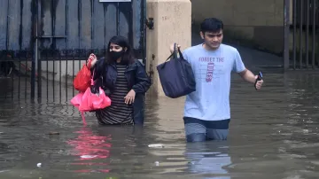 People make their way through the waterlogged streets at Kings Circle in Mumbai.- India TV Hindi