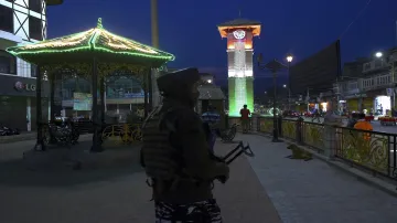 Security personnel stands guard at Lal Chowk illuminated in tricolour on the eve of 75th Independenc- India TV Hindi