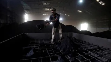 A laborer works inside a coal yard on the outskirts of Ahmedabad, India, in 2017- India TV Paisa