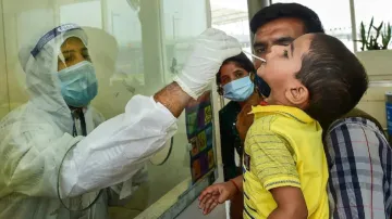 A health worker takes a swab sample of a child for Covid-19 testing.- India TV Hindi