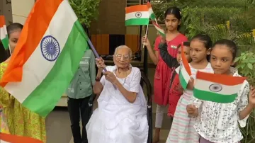 Mother of Prime Minister Modi, Heeraben distributes the National flag to children and hoists the the- India TV Hindi