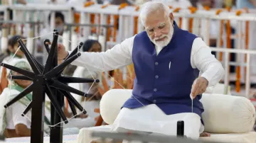 Prime Minister Narendra Modi tries his hand on a spinning wheel during Khadi Utsav in Ahmedabad- India TV Hindi
