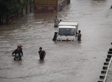 Commuters push their vehicle down the waterlogged Delhi Gurugram Expressway service road after rainf- India TV Hindi