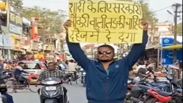 बीच रास्ते में पोस्टर लेकर खड़ा युवक।- India TV Hindi