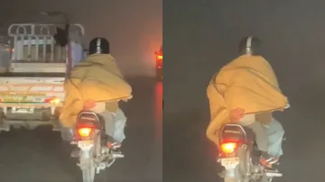 कड़कड़ाती ठंड में बाइक पर अपने बच्चे के साथ जाता हुआ पिता।- India TV Hindi