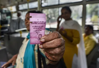 <p>A woman shows the 'pink ticket' during her ride on a DTC...- India TV Hindi