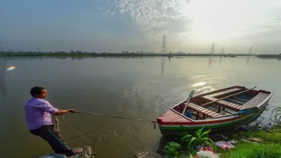 A man pulls his boat to anchor at the bank of swollen Yamuna River in New Delhi on Friday. The water- India TV Hindi