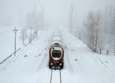कश्मीर घाटी के अनंतनाग का दृश्य, बर्फ से ढंके श्रीनगर-काजीगुड रेलवे ट्रैक से गुजरती ट्रेन 