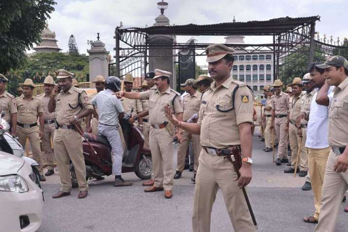 Police personnel stand guard at the entrance of the... Police personnel stand guard at the entrance of the...- India TV