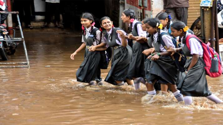 पश्चिम बंगाल के हुबली में बाढ़ के पानी के बीच स्‍कूल जाती छात्राएं 