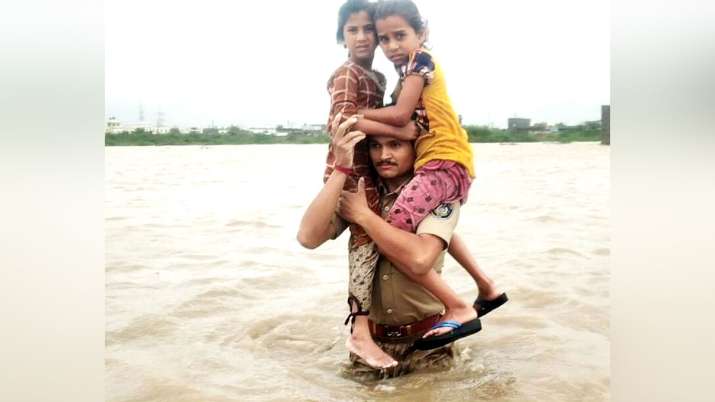 Constable Prithiviraj Singh Jadeja rescuing two girls from gujarat flood Constable Prithiviraj Singh Jadeja rescuing two girls from gujarat flood - India TV