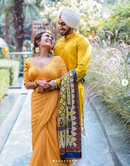 इन फोटोज में हाथों में मेहंदी लगाए नेहा कक्कड़ पीले रंग के आउटफिट में नज़र आ रही हैं। रोहनप्रीत ने भी इसी रंग से मैचिंग करते हुए शेरवानी पहनी है। 