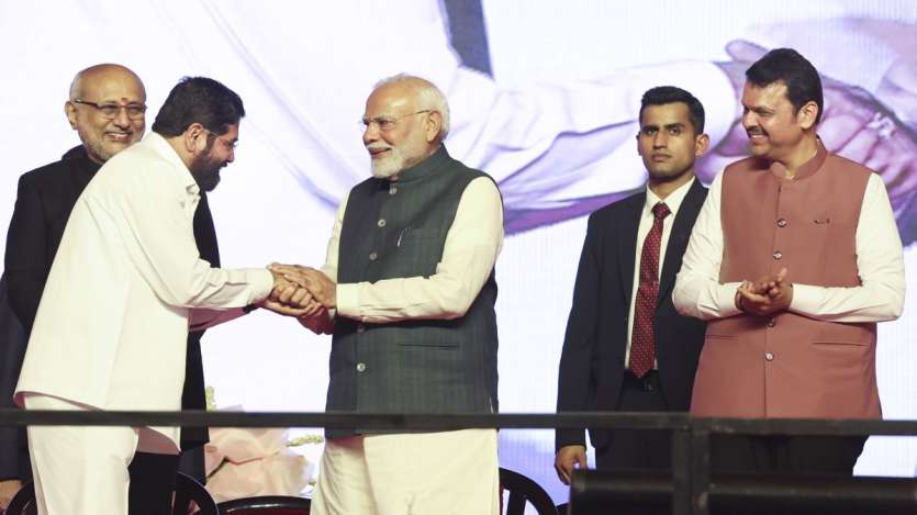 शपथ ग्रहण समारोह के दौरान एकनाथ शिंदे से कुछ यूं मिले पीएम मोदी। पास में खड़े देवेंद्र फडणवीस मुस्कुरा रहे हैं।