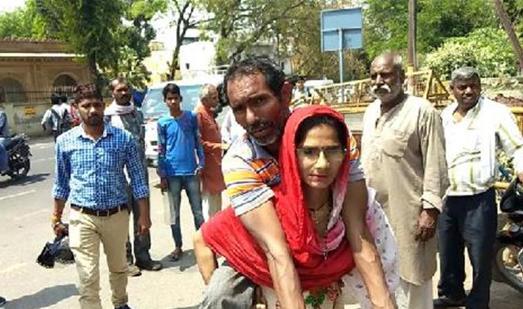 Woman in Mathura carries handicapped husband on shoulders to get disability certificate Woman in Mathura carries handicapped husband on shoulders to get disability certificate- India TV Hindi