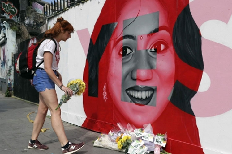 A woman places flowers by a mural showing Savita Halappanavar | AP Photo A woman places flowers by a mural showing Savita Halappanavar | AP Photo- India TV Hindi