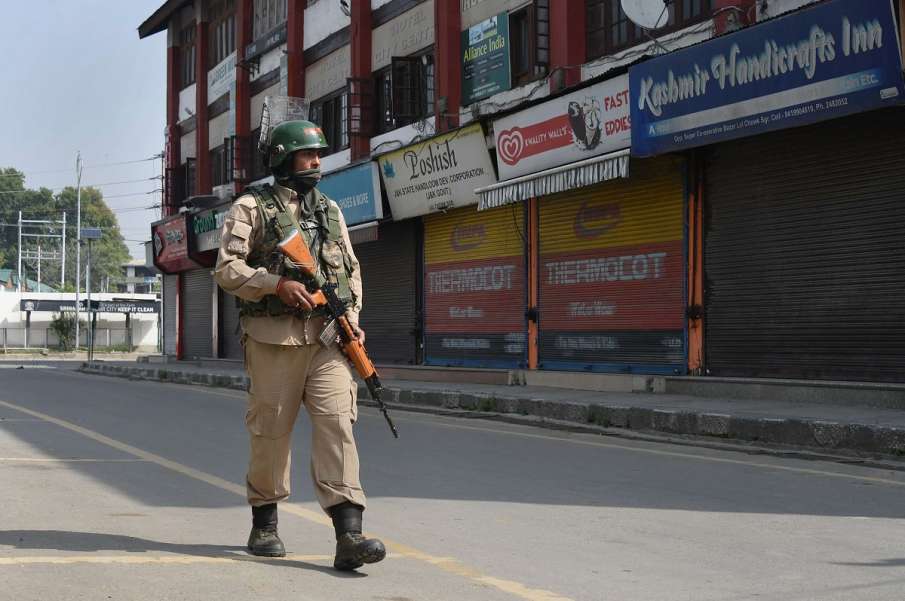 A security personnel patrols a street during... A security personnel patrols a street during...- India TV Hindi