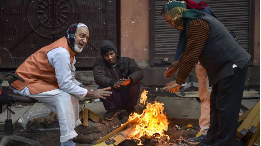 People warm themselves around a bonfire People warm themselves around a bonfire- India TV Hindi