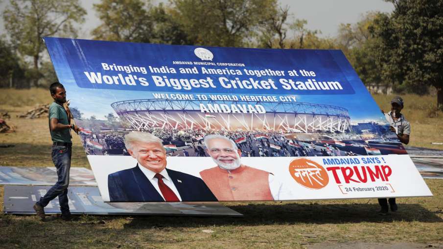 Workers carry a hoarding with pictures of the U.S... Workers carry a hoarding with pictures of the U.S...- India TV Hindi