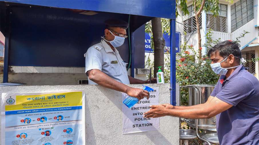 Kolkata: A police person provides hand sanitizer to a... Kolkata: A police person provides hand sanitizer to a...- India TV Hindi