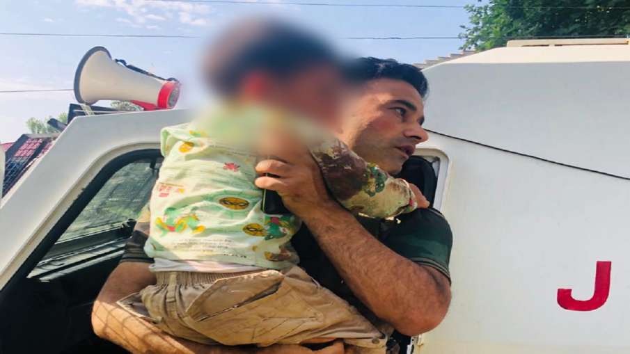 कश्मीर में गोलियों की तड़तड़ाहट के बीच बच्चे को गोद में उठाए रहे पुलिस ऑफिसर कश्मीर में गोलियों की तड़तड़ाहट के बीच बच्चे को गोद में उठाए रहे पुलिस ऑफिसर- India TV Hindi