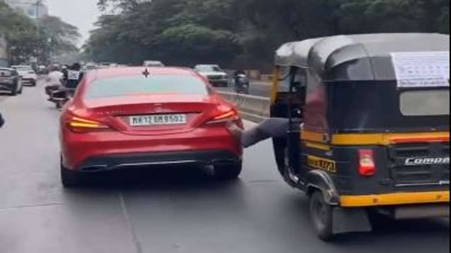 लाल मर्सिडिज कार को ऑटो वाला अपने पैर से धक्का लगा रहा है।- India TV Hindi